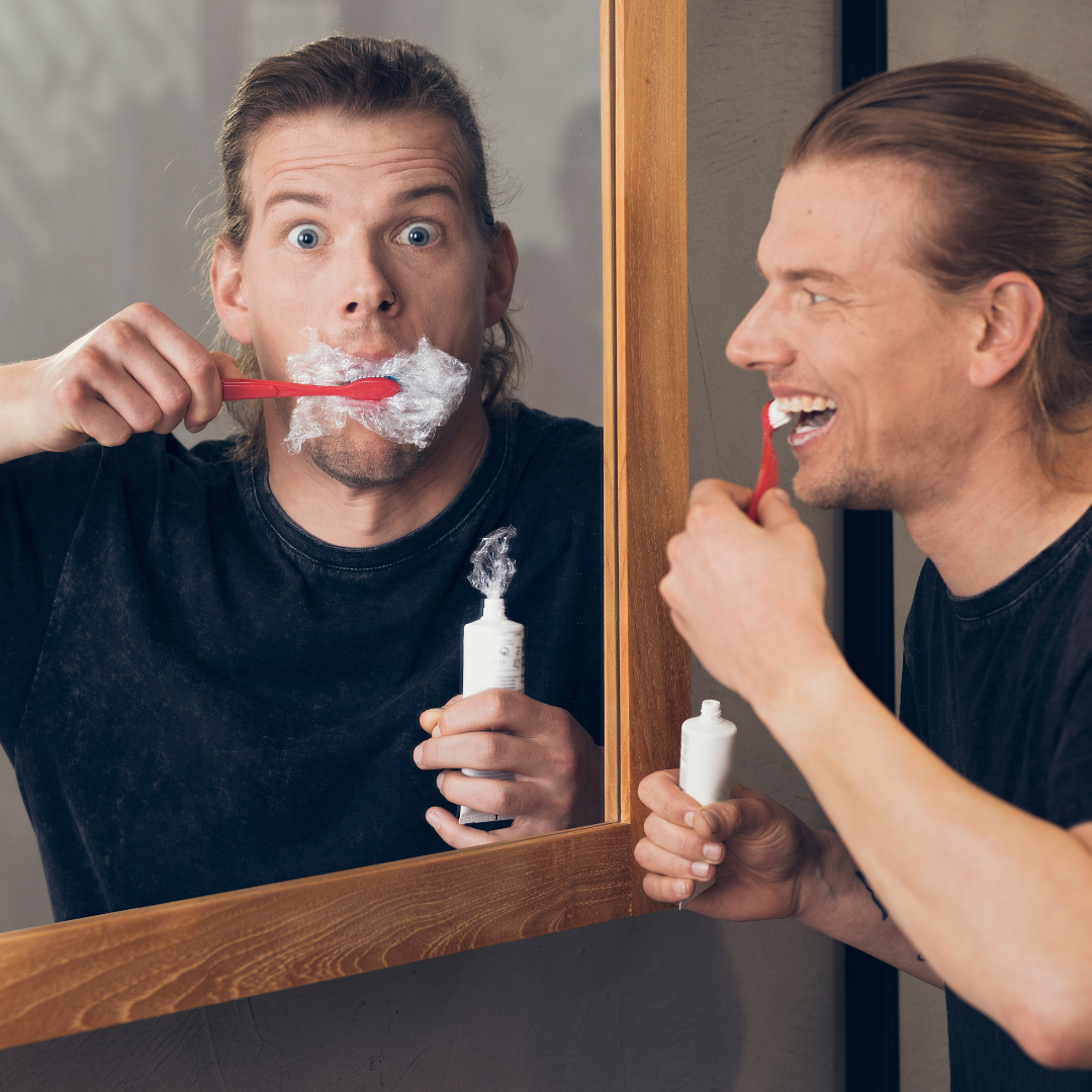 young man brushing his teeth with plastic toothpaste
